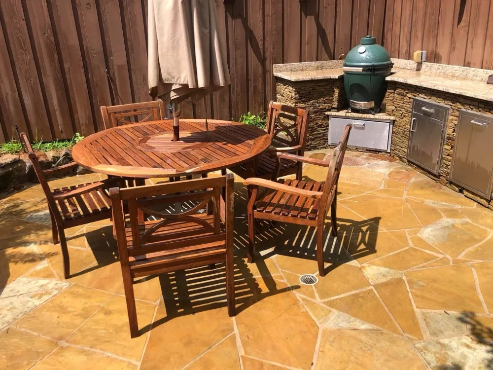 Restored rich brown teak patio table and chairs after cleaning